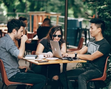 team members sitting a a table eating and working